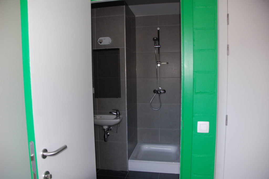 Sint-Jozefsstraat 30 - Kamer 21 - Deur naar badkamer met spiegel, lavabo en douche